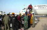 Des soldats des Forces armées indonésiennes aident des Indonésiens à embarquer dans un avion à destination de Jeddah, en Arabie saoudite, lors d'une opération d'évacuation, le 26 avril 2023 à Port-Soudan