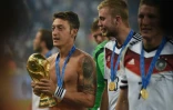 Le brillant trophée du Mondial dans les mains Mesut Özil, sacré avec l'Allemagne, le 13 juillet 2014 au Maracana à Rio de Janeiro