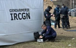 Des experts de l'Institut de Recherches criminelles de la Gendarmerie nationale (IRCGN) sur le site d'une fosse commune pendant l'exhumation de corps, le 14 avril 2022 Ă Boutcha, au nord-ouest de Kiev, en Ukraine