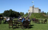 Des habitants de Cardiff profitent du soleil au pied du château avant un reconfinement local, le 27 septembre 2020 au Pays de Galles