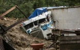 Un camion enseveli par la boue lors d'un glissement de terrain dû à l'ouragan Eta, le 7 novembre 2020 à Queja, au Guatemala