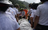 Des équipes de secours transportent le corps d'une victime d'un glissement de terrain, le 4 octobre 2015 à Santa Catarina Pinula, au Guatemala