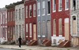 Un américain passe devant des maisons murées à l'est de Baltimore, le 8 août 2017