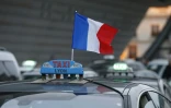 Un drapeau tricolore sur un taxi dont le chauffeur manifeste le 26 janvier 2016 à Paris