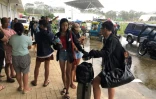 Des touristes affluent dans un complexe sportif tranformé en refuge, le 16 décembre 2021 à Dapa, sur l'île de Siargao aux Philippines