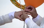 Les Chinois Song Jihan et Wang Zengyi échangent leurs alliances lors de leur mariage près de Pattaya, en Thaïlande, le 31 mai 2025
