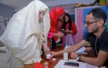 Une femme trempe son doigt dans un pot d'encre après avoir voté, dans un bureau de vote de Tunis, le 15 septembre 2019.
