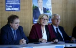 Marine Le Pen (c) s'adresse aux médias lors d'une tournée  à Pruno en Corse, le 26 novembre 2017 pour soutenir les candidats du FN Charles Giacomi (g) et Francis Nadizi (d) dans le cadre des élections pour  choisir une nouvelle collectivité unique