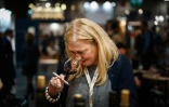 L'acheteuse de vin britannique Liz Donnelly goûte un vin de la Cave de Gan-Jurançon lors du salon Wine Paris et Vinexpo Paris la Porte de Versailles, le 13 février 2024 à Paris