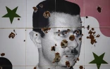 Des impacts de balles sur une peinture murale représentant le président syrien déchu Bachar al-Assad dans la ville d'Adra,près  de Damas, le 25 décembre 2024