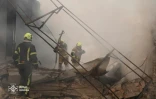 Photo diffusée par le Service d'État ukrainien pour les situations d'urgence, le 11 juillet 2026, montrant des pompiers luttant contre un incendie dans un entrepôt endommagé par une frappe de missiles russes à Kiev, en Ukraine