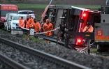 Des équipes de secours sur le site d'un déraillement de train régional à Lüscherz, au nord-ouest de Berne, le 31 mars 2023 en Suisse