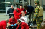 Une victime entourée des secouristes le 22 mars 2016 près de la station de métro de Maalbeek à Bruxelles