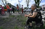Une Ukrainienne attend de l'aide humanitaire à Bucha, au nord-ouest de Kiev, le 16 juin 2022