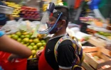 Un jeune garçon porte un masque en plexiglas au marché de San Cosme à Mexico le 10 août 2020