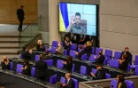 Le président ukrainien Volodymyr Zelensky applaudi par le chancelier allemand Olaf Scholz et les membres du Bundestag lors d'une intervention vidéo, le 17 mars 2022 à Berlin