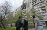 Des habitants observent un incendie dans un immeuble résidentiel à la suite d'un frappe, dans les faubourgs de Kharkiv (est de l'Ukraine), le 22 avril 2022
