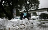 Des personnes marchent sur des sacs remplis de pierres et de sable dans le centre historique de Porto Alegre, dans l'Etat du Rio Grande do Sul, au Brésil, 12 mai 2024