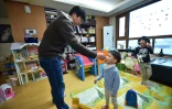Kim Jin-Sung donne un médicament à son fils dans leur appartement de Séoul le 22 décembre 2015