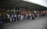 Des habitants attendent un moyen de transport à un arrêt de bus pendant la panne de courant entraînant la fermeture du métro, dans le quartier de Petare à Caracas, le 26 mars 2019