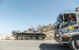 Des combattants amhara passent en camion à cÎté d'un char abandonné, le 22 novembre 2020 prÚs de Humera, en Ethiopie