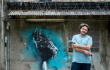 Le graffeur Christian Guemy, alias C215, pose Ă Fresnes devant une de ses oeuvres