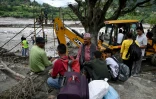 Des habitants regroupés près de la rivière Trishuli tandis que des ouvriers installent une tyrolienne au dessus du cours d'eau à Bidur au Népal le 2 septembre 2026