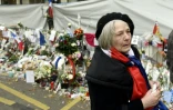 Une femme avec une écharpe tricolore autour du cou, le  27 novembre 2015 devant le Bataclan à Paris