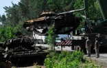 Des soldats ukrainiens récupèrent un char russe détruit à Dmytrivka, village de la région de Kiev, le 20 juin 2022