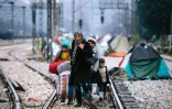 Une femme et trois enfants marchent sur des rails reliant la Grèce à l'Europe de l'ouest, à la frontière gréco-macédonienne près du village grec d'Idomeni, le 9 mars 2016