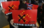 Des manifestants brandissent des drapeaux chinois où les étoiles ont été disposées en croix gammée, à Hong Kong le 29 septembre 2019