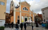 Des piétons devant la cathédrale d'Ajaccio en Corse la veille de la visite du pape François sur l'île, le 14 décembre 2024