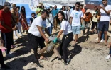 Des spectateurs regardent une tortue d'une espèce protégée être relâchée sur la côte de Sfax, dans le centre-est de la Tunisie, le 15 octobre 2023