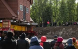 Des personnes assistent au déplacement de l'église en bois de Kiruna, le 16 août 2025 à Kiruna, en Suède