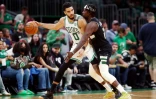 Jayson Tatum des Boston Celtics protège son ballon devant Jrue Holiday des Milwaukee Bucks dans le match 7 de la demi-finale de Conférence Est en NBA le 15 mai 2022 au TD Garden à Boston