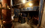 Une religieuse prie le 20 décembre 2016 devant la grotte de l'Eglise de la Nativité, où Jésus-Christ est né selon la tradition chrétienne, à Béthléem en Cisjordanie