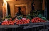 Une femme vend des légumes juste avant le couvre-feu dans le bidonville de Kibera, à Nairobi le 5 mai 2020