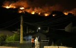 Des habitants observent les flammes sur les crêtes des collines tandis que les pompiers luttent contre un incendie de forêt dans la région de Cebreros, près d’Ávila, à 80 km à l’ouest de Madrid, dans la nuit du 24 juillet 2026
