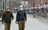 Des policiers portant des masques de protection dans une rue de Srinagar, au premier jour du confinement instauré en Inde pour lutter contre l'épidémie du nouveau coronavirus, le 25 mars 2020