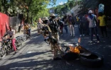 Des policiers éteignent des feux de barricades allumés par des manifestants contestant la hausse du prix de l'essence à Port-au-Prince, Haiti, le 10 décembre 2021