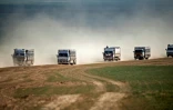 Photo prise le 11 février 2019 montrant un convoi de camions transportant des civils fuyant le dernier réduit jihadiste dans l'est de la Syrie