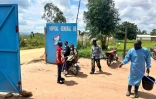 Un membre du personnel médical porte un équipement de protection à l'entrée de l'hôpital de Rwampara, l'un des foyers de l'épidémie d'Ebola, le 19 mai 2026 en RDC