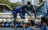 Des employés déchargent des bonbonnes d'oxygène dans une station de distribution d'urgence à Jakarta, le 5 juillet 2021