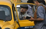Un client monte dans un taxi Ambassador garé devant une gare à Calcutta, le 5 février 2025 en Inde