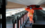 Un agent du Technicentre Atlantique de Châtillon désinfecte les emplacements à bagages dans un TGV, le 14 mai 2020 dans les Hauts-de-Seine