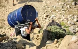 Un homme transporte un baril de nourriture sur la seule route entre Aden et Taëz, dans le sud-ouest du Yémen, le 26 décembre 2015