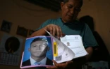 Reynaldo Santos, père de Jonathan Santos qui est en attente d'un procès, montre une photo de son fils et un certificat prouvant qu'il n'a pas de casier judiciaire, lors d'un entretien avec l'AFP à son domicile de Soyapango, au Salvador, le 9 mars 2026