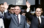 Le dernier dirigeant de l'URSS, Mikhaïl Gorbatchev (au centre) salue la foule avec le président français Francois Mitterrand (à droite), alors en visite en URSS, le 9 juillet 1986