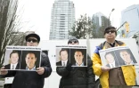 Des manifestants tiennent des photos de deux Canadiens interpellés en Chine, devant la Cour suprême de Vancouver, le 6 mars 2019 au Canada