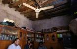 Une famille irakienne sous un ventilateur, à Hilla, dans le centre de l'Irak, le 10 août 2025